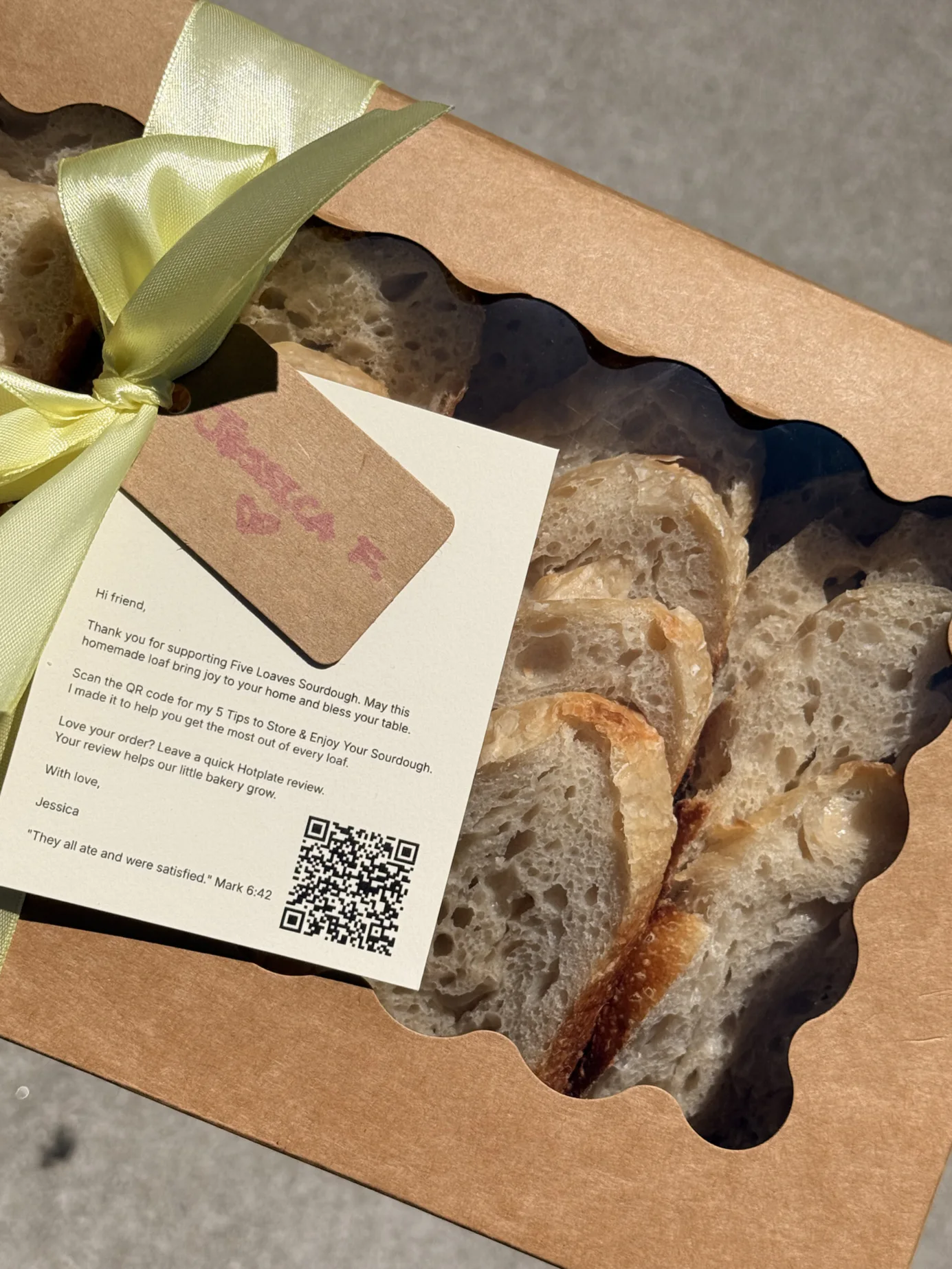 Sliced Five Loaves sourdough bread in a gift box with ribbon and a thank-you card